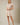 Shop Wall beige striped mini dress with notch neck, short sleeves, and smocked waist on a blonde model