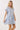 Printed Notch Neckline Tiered Mini Dress modeled by a smiling woman with blonde hair, showcasing its floral print and flowy fit.