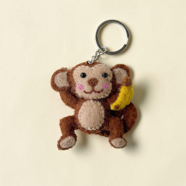 Monkey with Banana Felt Wool Keychain attached to a beige woven tote bag