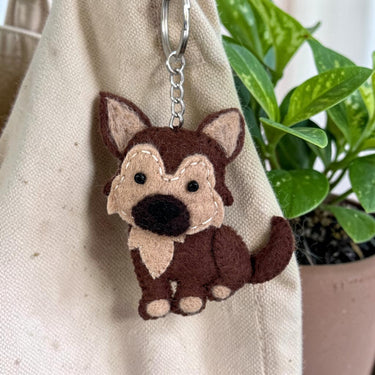 German Shepherd Puppy Dog Felt Wool Keychain hanging from a bag
