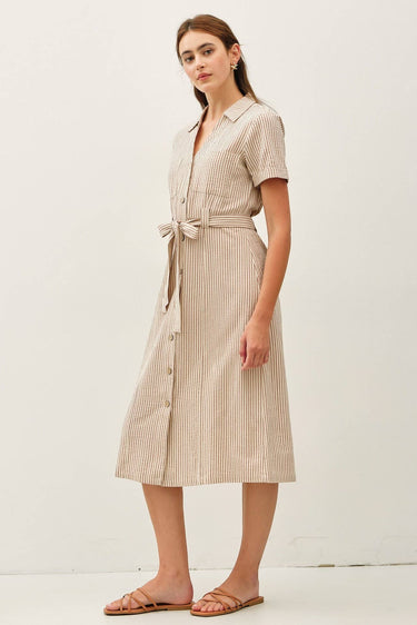Model wearing a striped cotton midi dress featuring buttons, collar, and tied waist with front pockets.