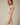 Shop Wall model wearing a beige and white striped notch neck short sleeve mini dress with a smocked waist